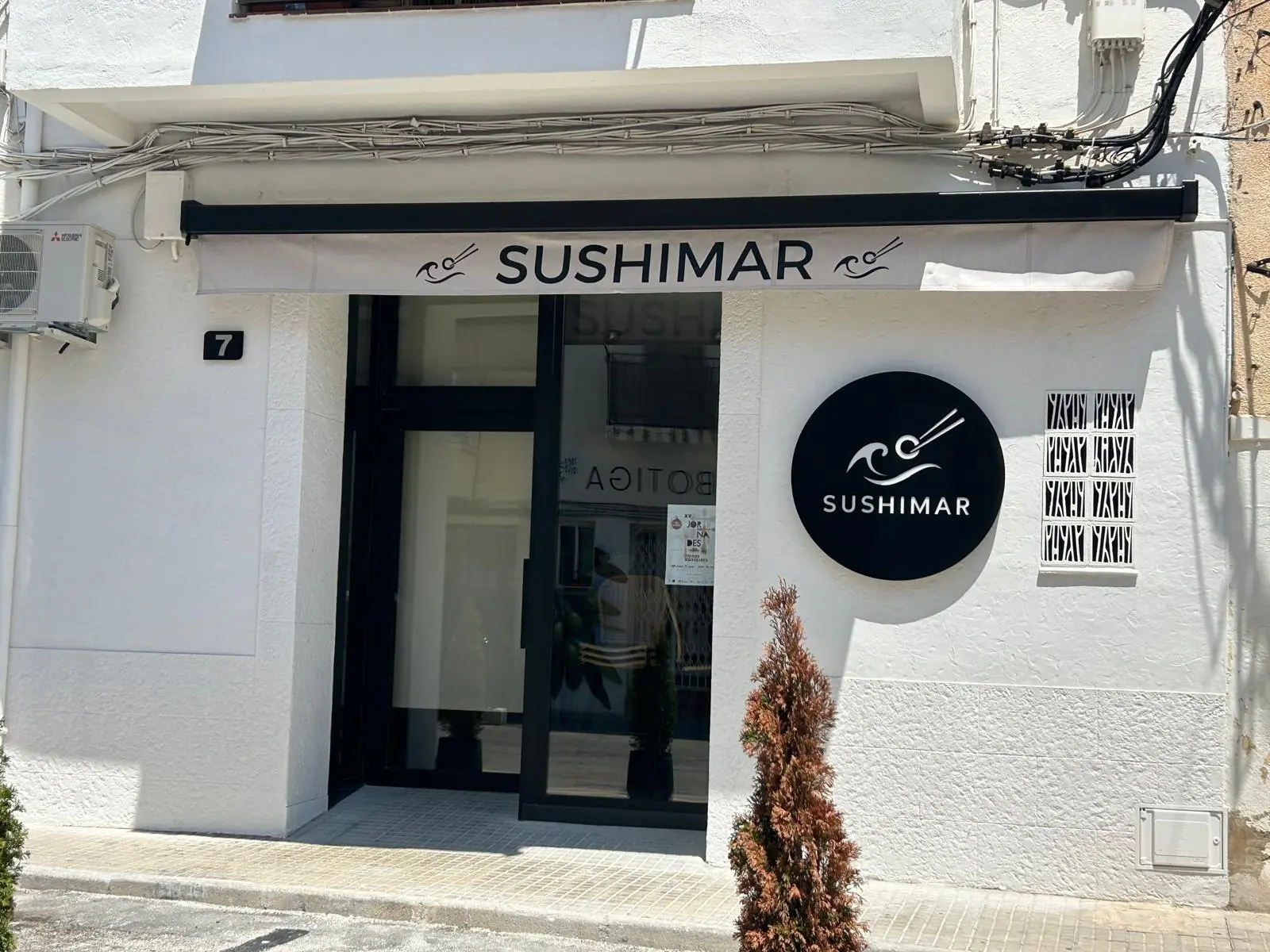 Façana blanca de SushiMar al carrer Major, amb el toldo i el rètol negres.